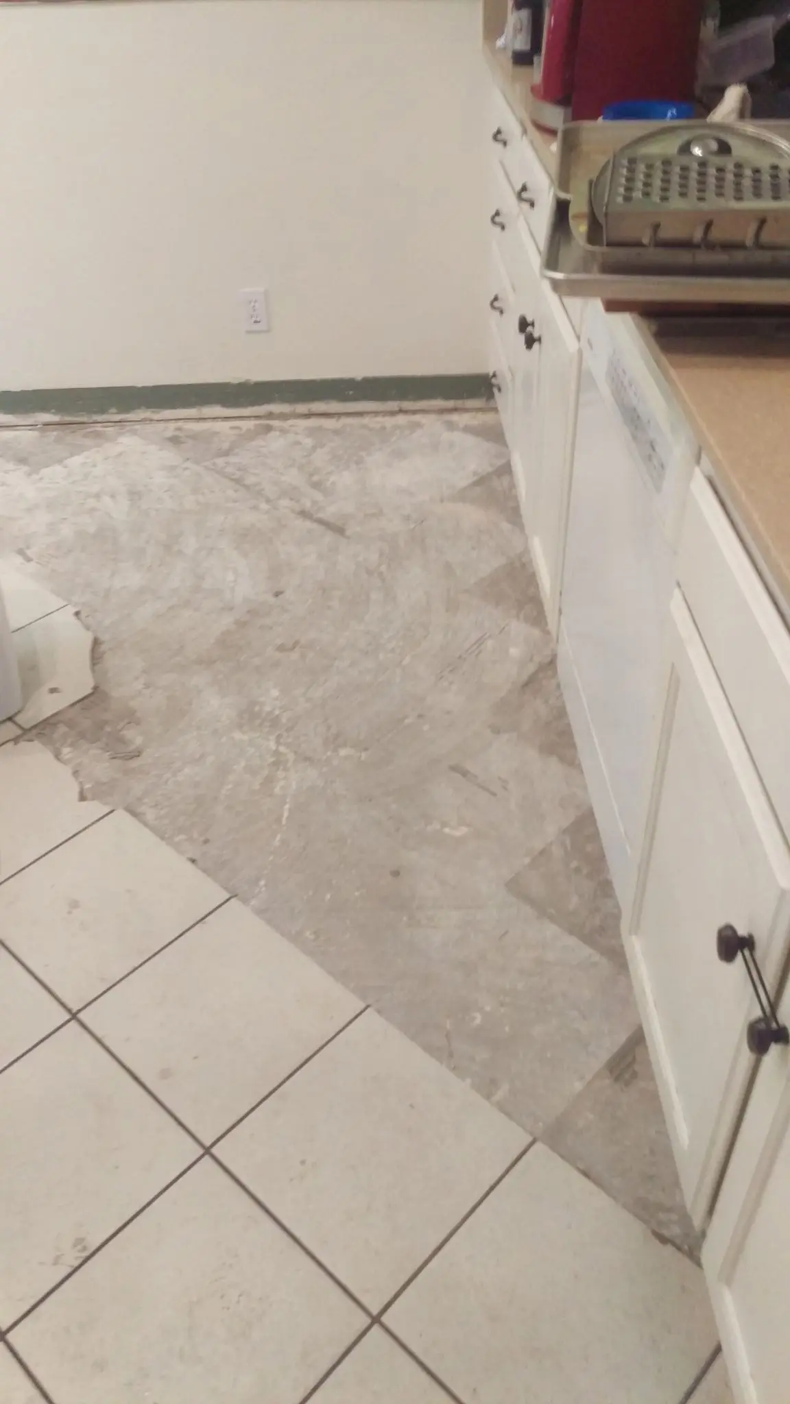 Subfloor exposed along the cabinets